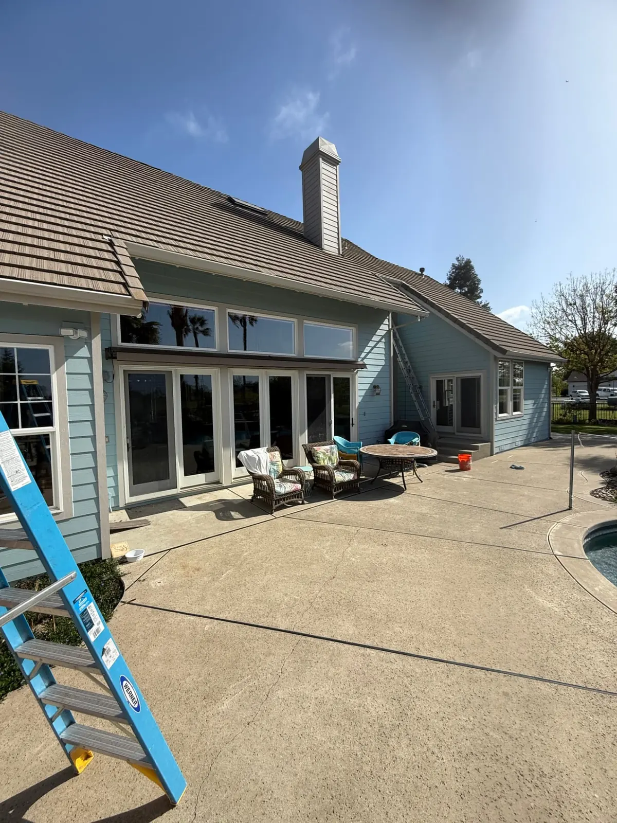 Rear elevation of a single-story Wilton home with large sliding glass doors and transom windows cleaned by CSG