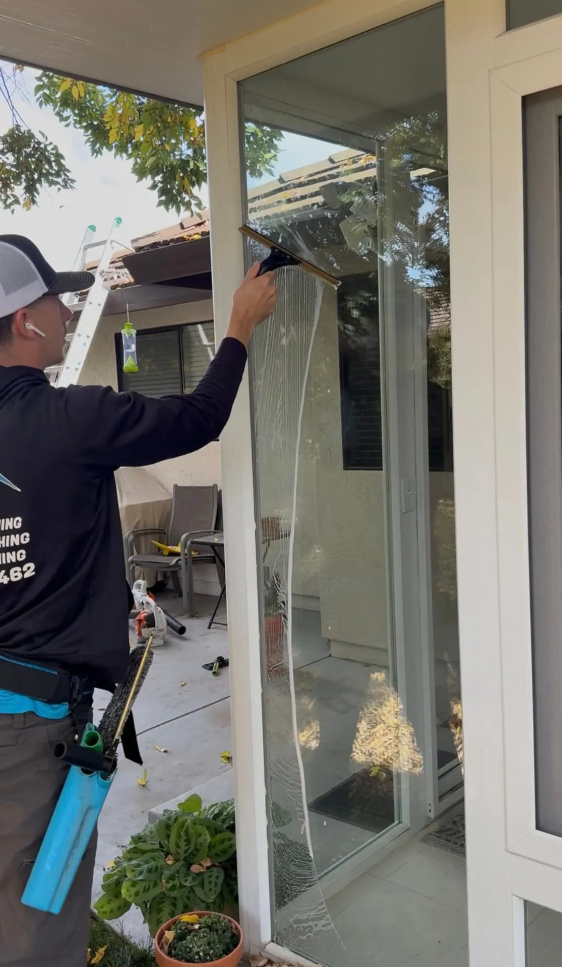 CSG technician squeegeeing an exterior patio door window on a Sacramento home in the Pocket area