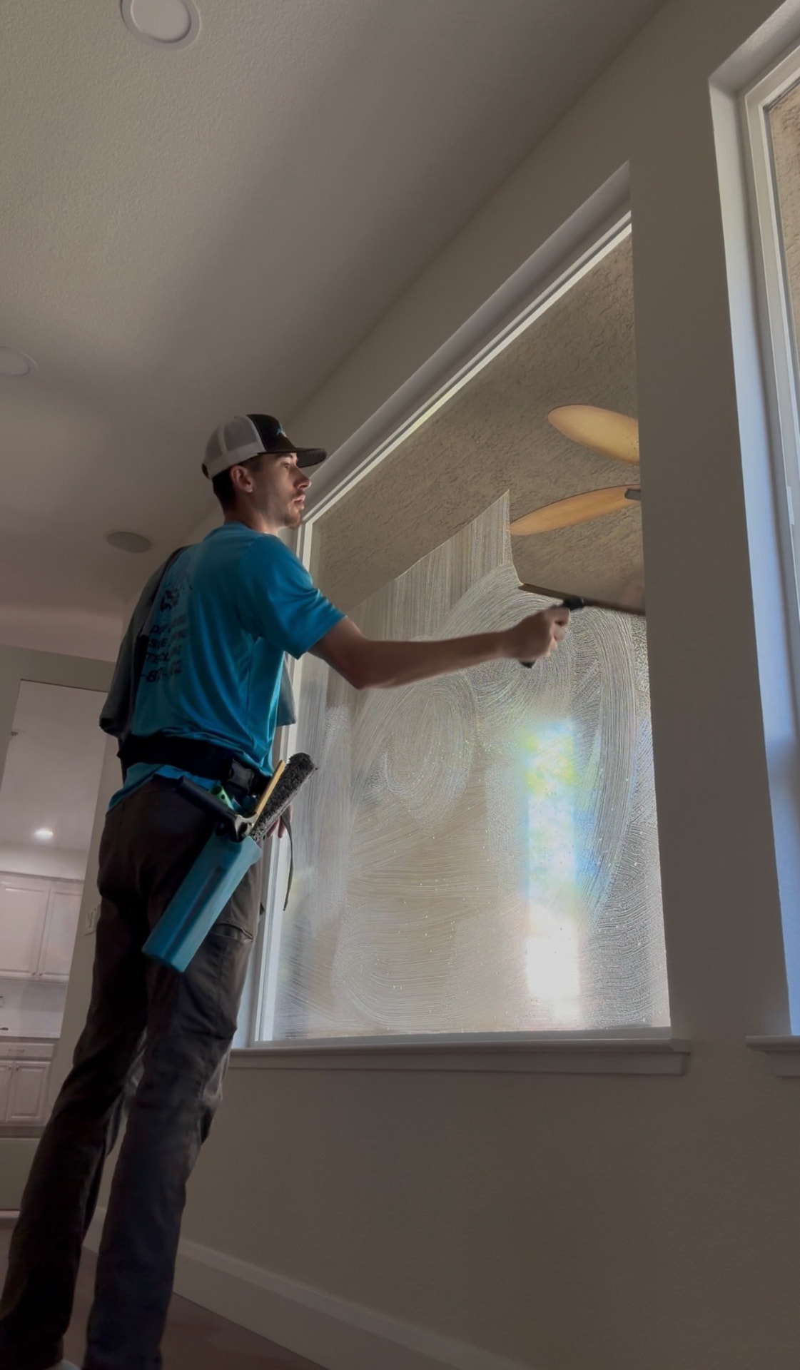 CSG technician squeegeeing an interior window inside a home