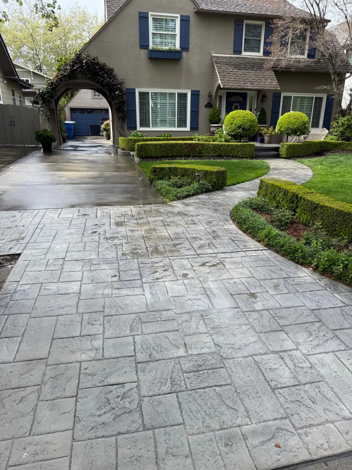 Stamped concrete driveway and stucco two-story home in East Sacramento after a CSG house wash and driveway cleaning