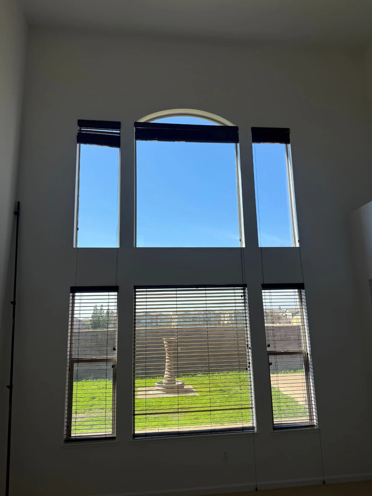 Tall arched interior windows cleaned inside a two-story living room